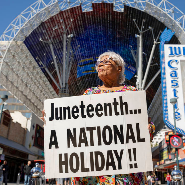 Opal Lee holding a "Juneteenth...A National Holiday" poster