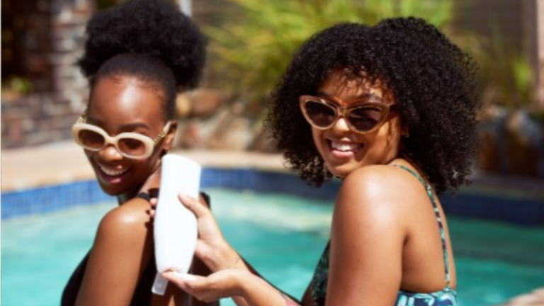 Black girls with sunscreen in hand