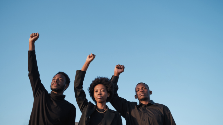 3 black people with black power fists in the air